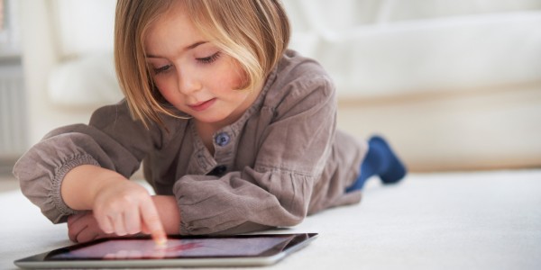 Girl lying on floor using digital tablet